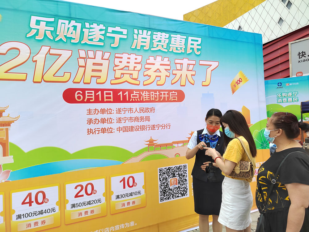 1遂宁市消费券发放启动仪式现场，建行员工为市民介绍使用方法.jpg