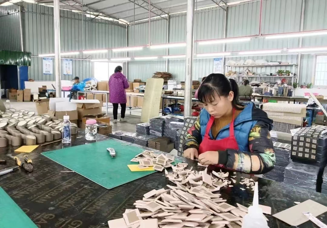 图为位于该区桥巩镇的广西金慧首饰包装有限公司帮扶车间工人在忙碌生产。.png