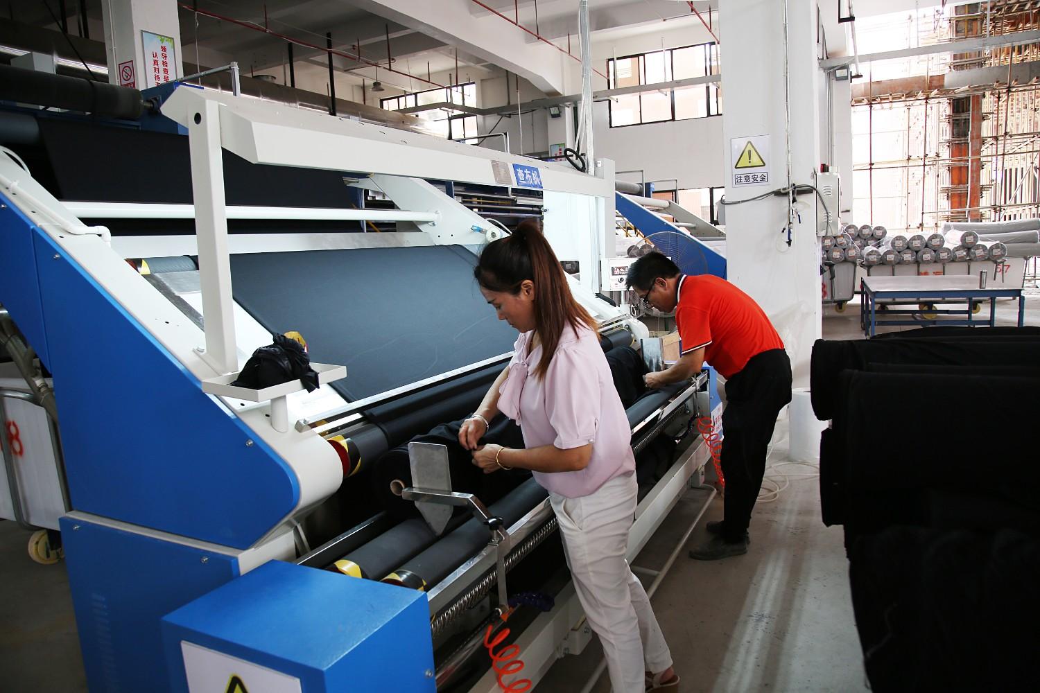 中国（贵港）纺织服装时尚新区入园企业工人在调试设备（莫新雄摄）.jpg